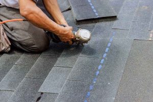 roofer installing asphalt shingles